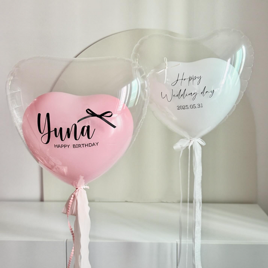 Ballon cœur transparent avec ballon rose à l'intérieur et message personnalisé “Happy Birthday” en vinyle noir, idéal pour anniversaire ou mariage.